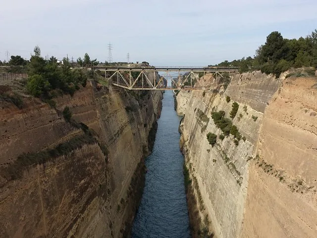 a deep canal with steep rocky walls and a bridge crossing over it