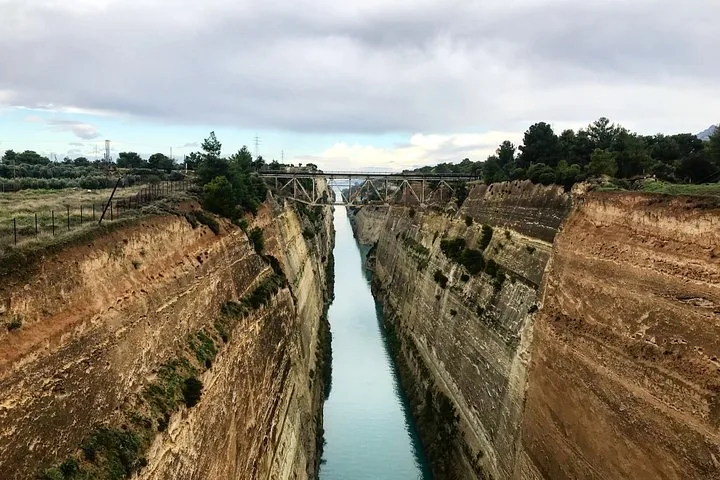 a deep canal with steep rocky sides and a bridge in the distance