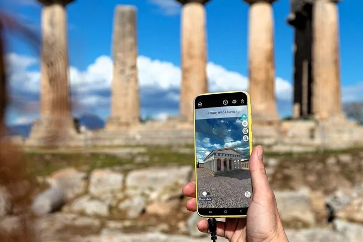 a person holding a smartphone showing an augmented reality view of ancient ruins