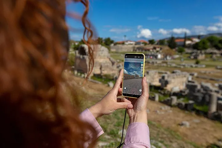a person using a smartphone to view augmented reality of ancient ruins